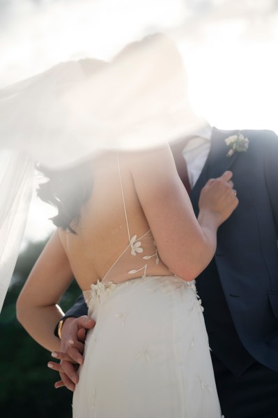 Sunshine ray over bride and groom dress from behind